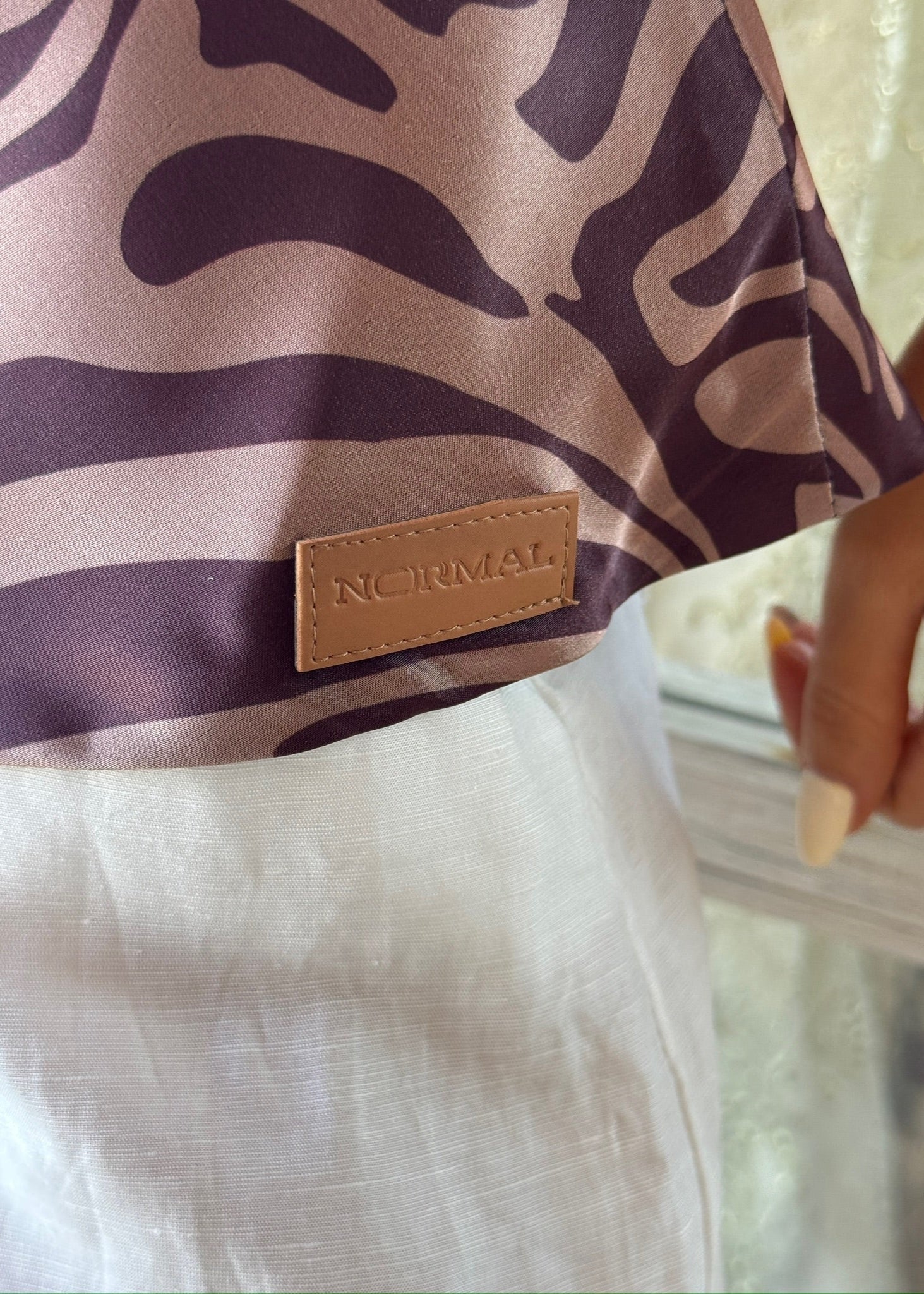 Zebra-patterned garment with a 'NORMAL' label on a blurred background