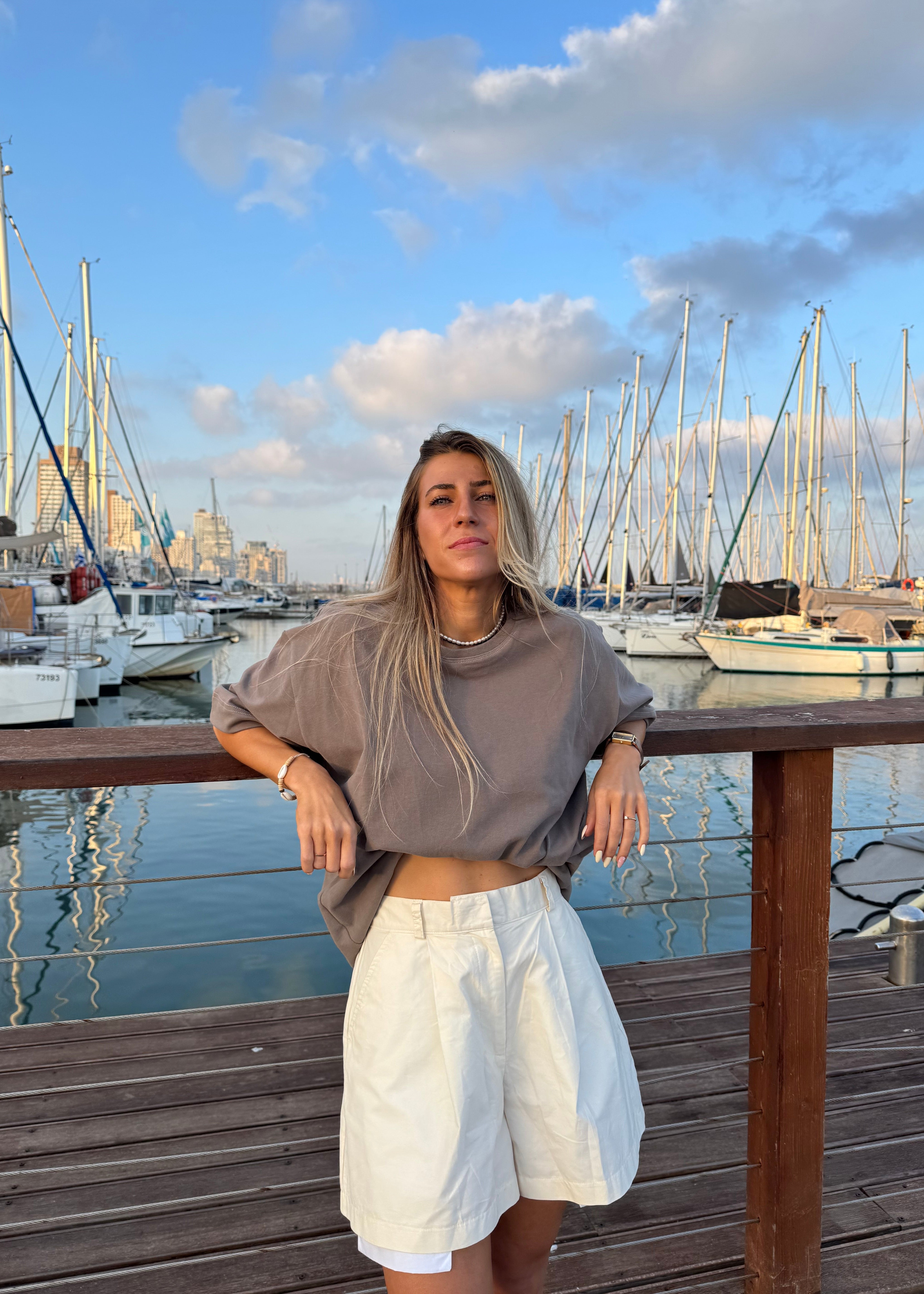 Person standing on a wooden deck with a scenic background